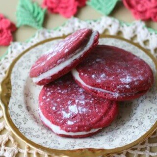 Red velvet sandwich cookie recipe has rich white chocolate and bourbon ganache in the center - perfect for holiday giving! From RestlessChipotle.com