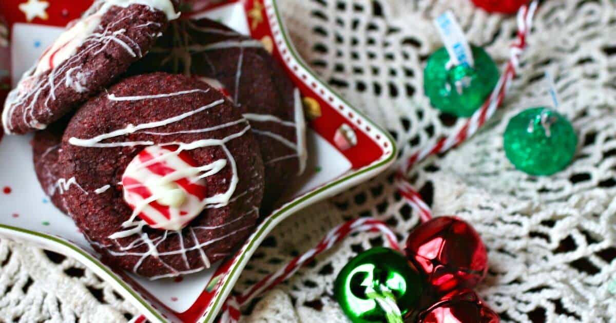 Chocolate cookies in a star shaped dish with red and green bells around.