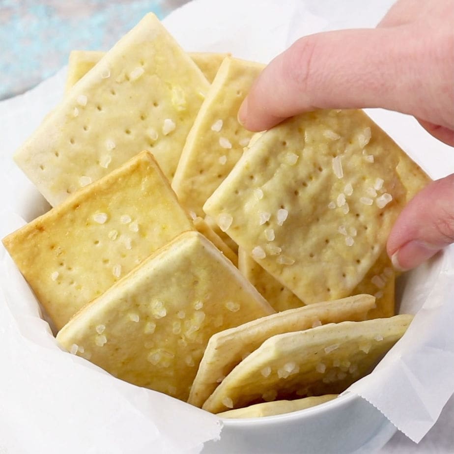 Someone getting a cracker out of a bowl