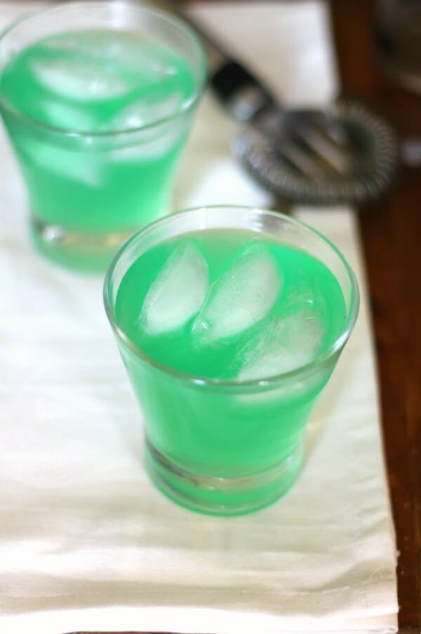 Overhead view of two green Hulk cocktails in glasses.