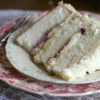 This Southern Coconut cake is three layers of amazing! Raspberry filling, fluffy whipped white chocolate frosting. From RestlessChipotle.com