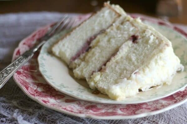 This Southern Coconut cake is three layers of amazing! Raspberry filling, fluffy whipped white chocolate frosting. From RestlessChipotle.com