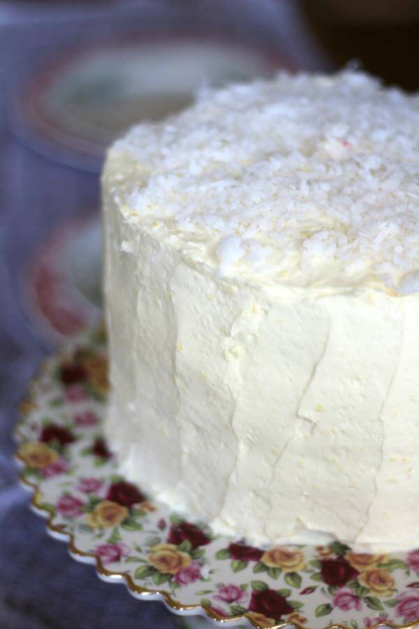 This Southern Coconut Cake is filled with tangy raspberry jam and covered with a whipped white chocolate frosting. SO good! From RestlessChpotle.com