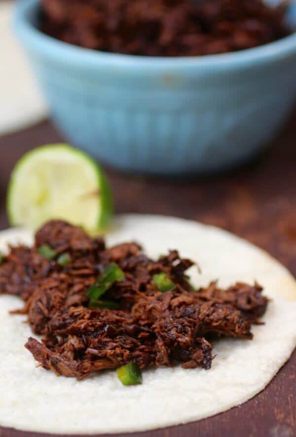 Slow cooked shredded beef is simmered all day in red eye gravy. Use it in sliders or tortillas. SO yummy! From RestlessChipotle.com