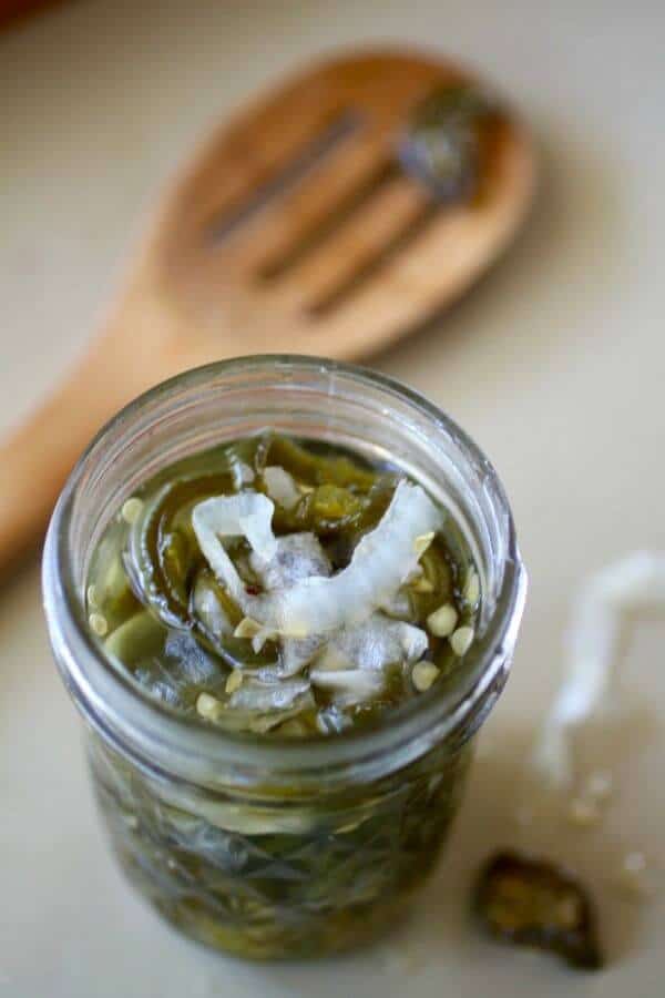 Overhead view of a jar of candied jalapenos.