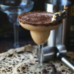 A creamy chocolate cocktail on a white lace tablecloth.