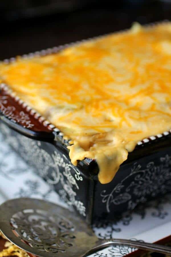Closeup of the casserole dish filled with the recipe and cheese melting over the side.