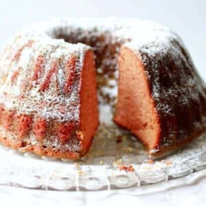 A cherry Dr Pepper bundt cake dusted with confectioner's sugar.
