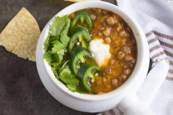 Lentil soup garnished with jalapeno, cilantro, and sour cream.