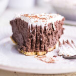 A chocolate pie with a bite removed showing the ultra creamy texture of the filling.