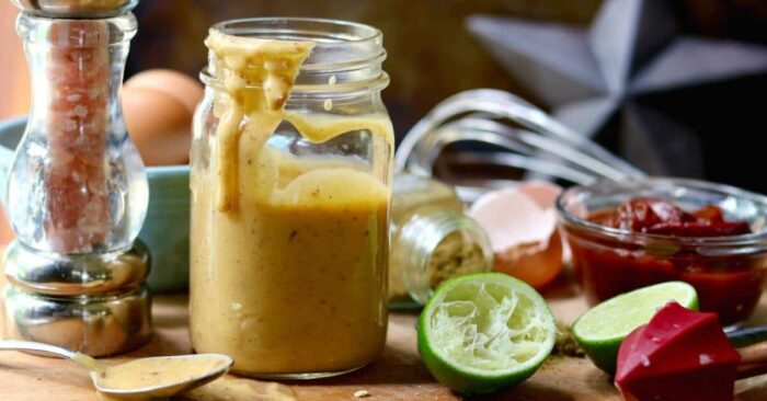 Chipotle aioli in a glass jar with ingredients surrounding it.