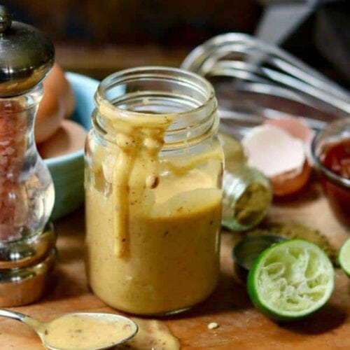A jar of aioli surrounded by ingredients.