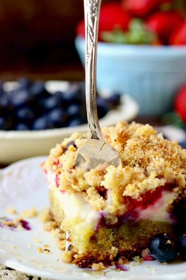 Closeup of a fork cutting through a serving of coffee cake showing the different layers.