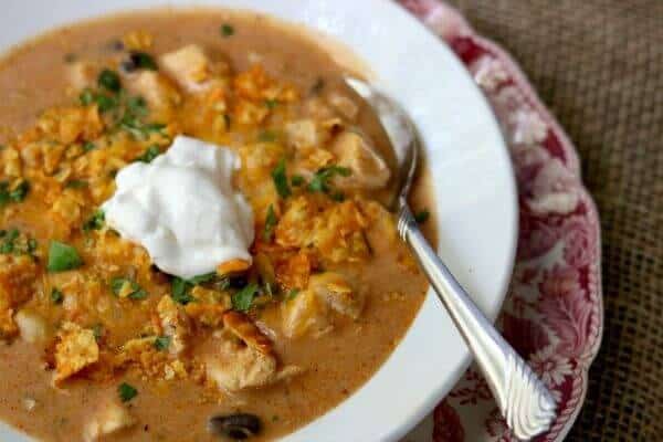 Creamy chicken enchilada soup recipe is ready in minutes! From RestlessChipotle.com