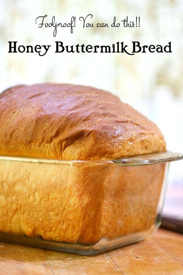 A loaf of honey buttermilk bread cooling in a glass baking dish.