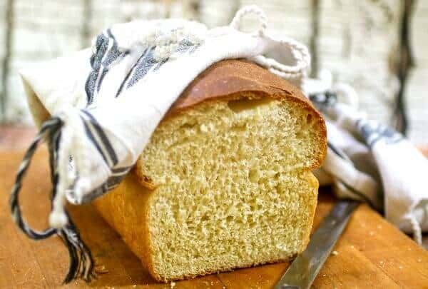 Homemade white bread is sliced on a cutting board - feature image.