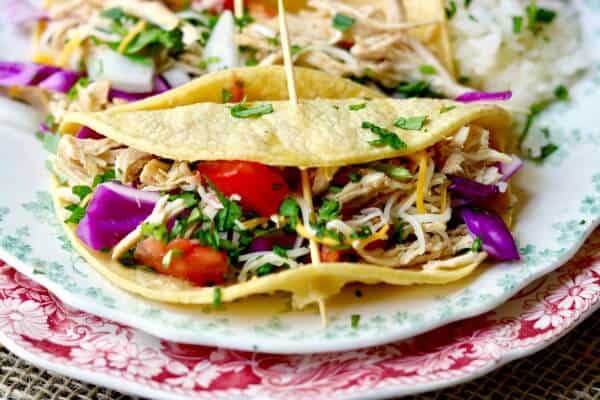 Easy! Slow cooker tequila lime chicken tacos is an easy Tex-Mex dinner recipe that cooks right in your crock pot all day long. Use chicken thighs or breast for a deliciously easy weeknight meal! Perfect for a weekend taco bar! From RestlessChipotle.com