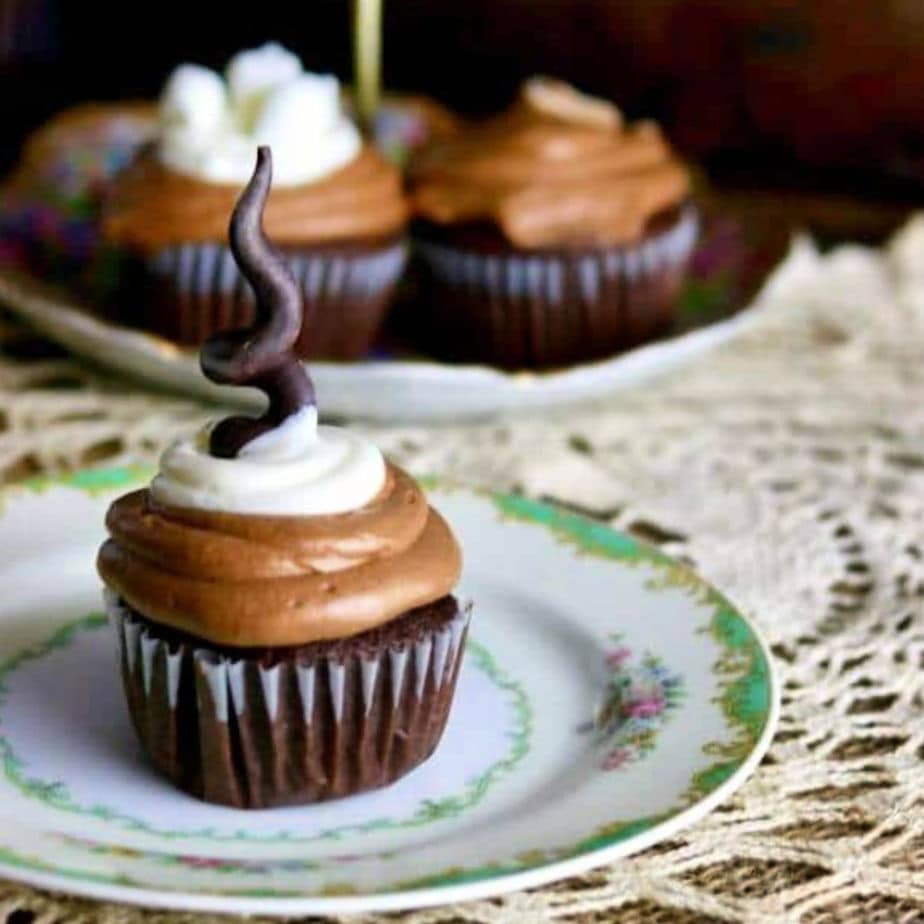 A chocolate cupcake on a green and white plate.