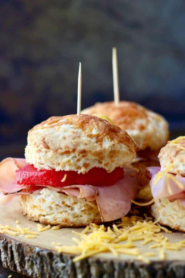 Closeup of spiced apple and ham sliders on a cheddar cheese biscuit.