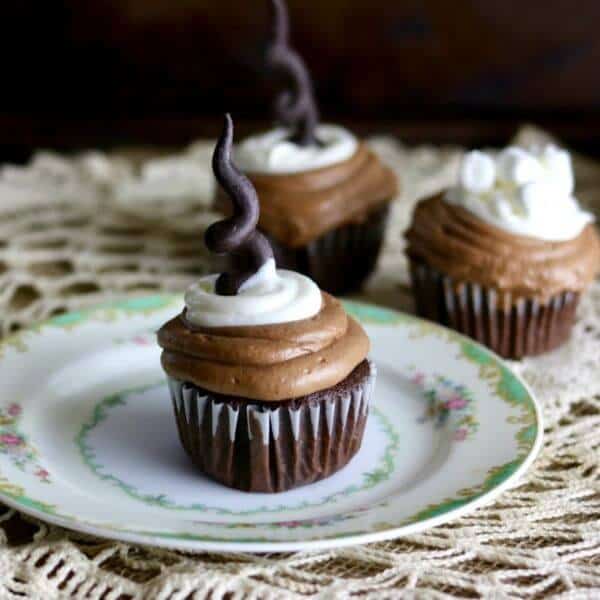 Square image of three Mexican hot chocolate cupcakes on a lace tablecloth