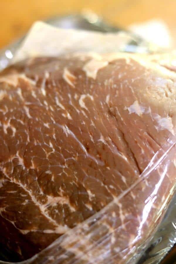 A cut of well marbled beef is ready to be made into slow cooker pot roast.