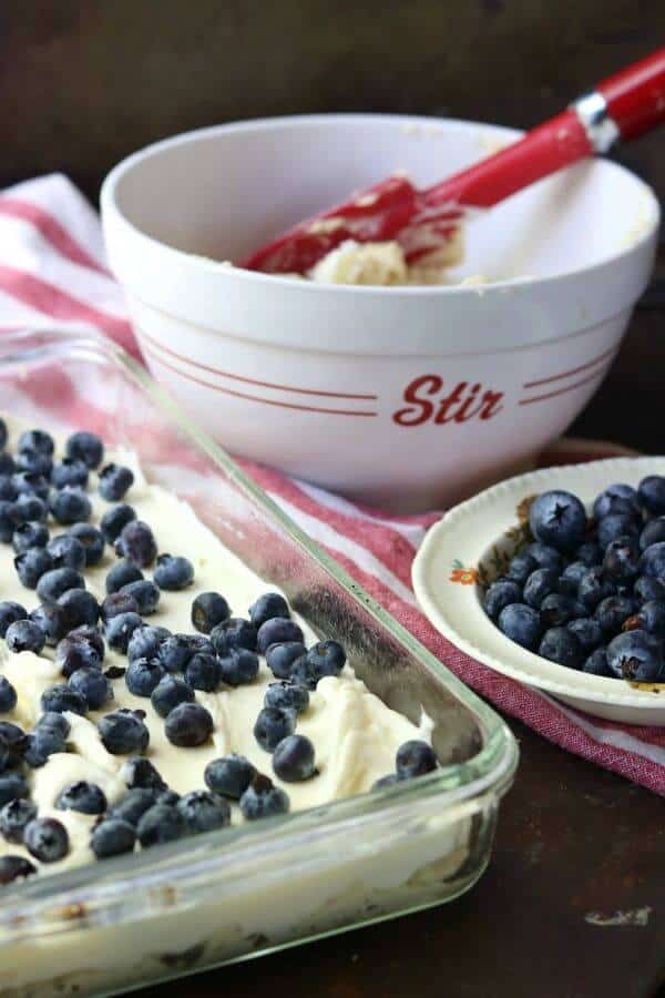 Blueberry cream cheese coffee cake being assembled in a pan.