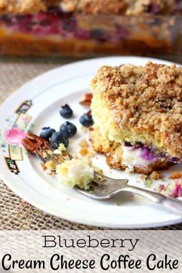 blueberry cream cheese coffee cake square on a white plate with a silver fork. Title image