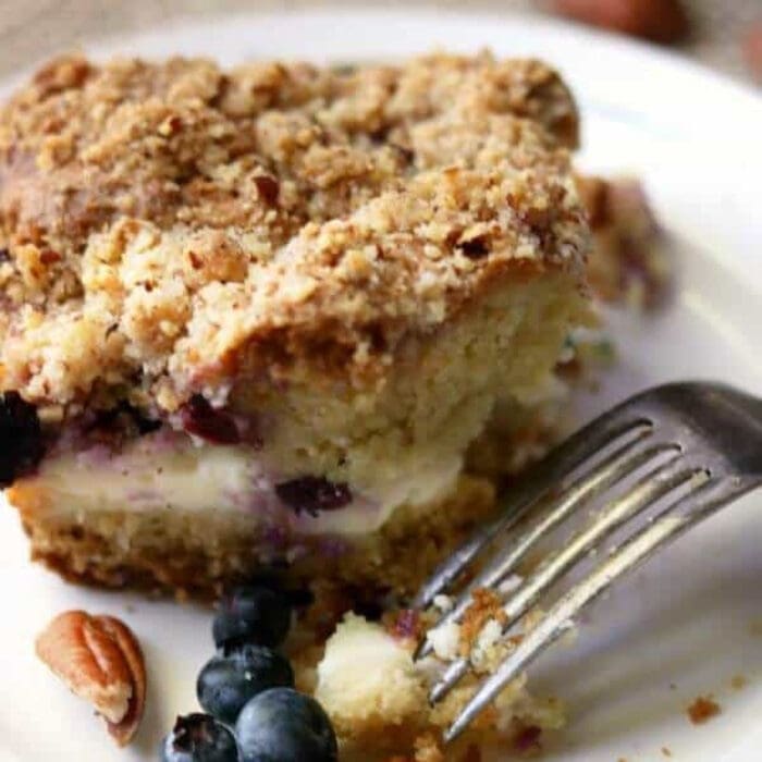 Closeup of blueberry cream cheese coffee cake with a bite taken out of it.