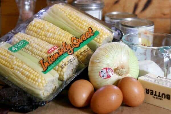 Ingredients on the counter for southern corn pudding - eggs, onion, corn, butter, and flour.