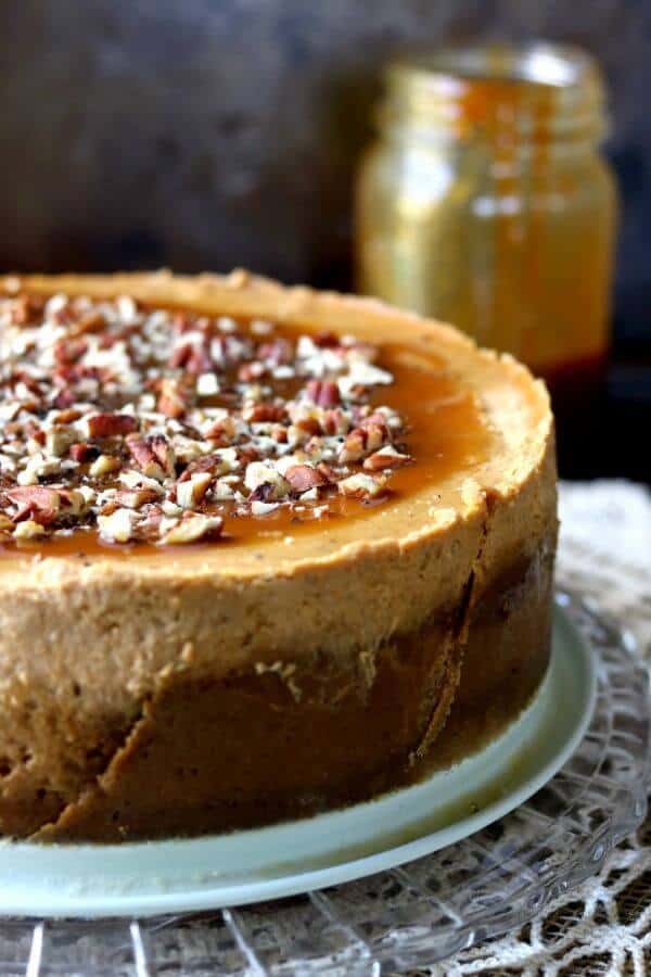 A large pumpkin cheesecake with gingersnap crust waits to be cut into 