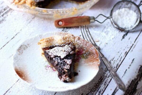 A horizontal image of chocolate chess pie with a silver fork next to it. Feature image.