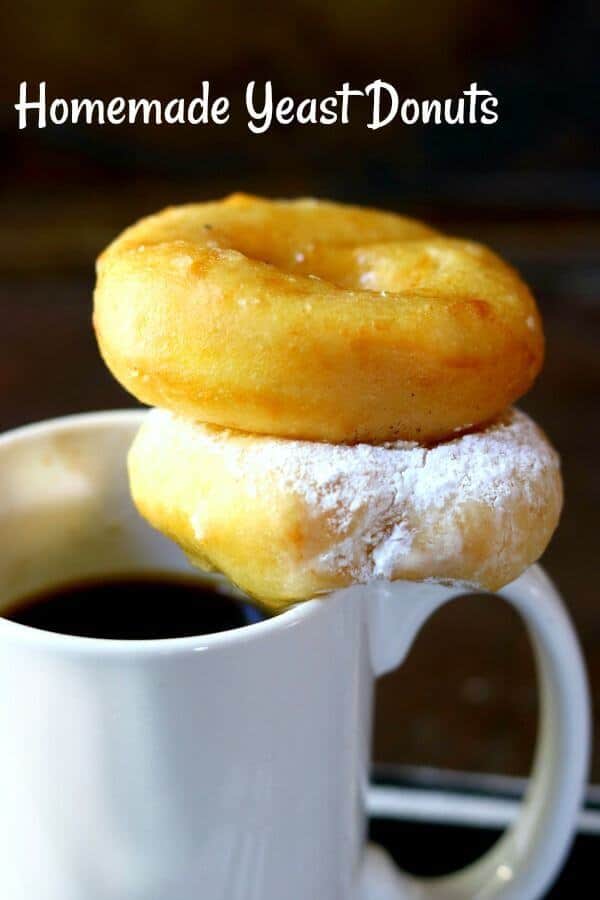 Two homemade yeast donuts stacked on a white coffee cup - title image for homemade donut recipe. 