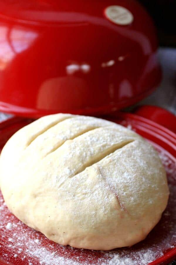 Risen bread dough is shaped, scored.
