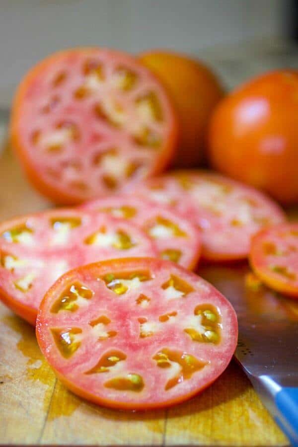 Sliced, partially ripened tomatoes for fried green tomatoes recipe.