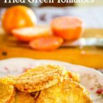 Fried green tomatoes on a platter with sliced tomatoes in the background. Title image.