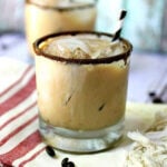 Creamy iced coffee cocktail in a glass with a coffee dust rim.
