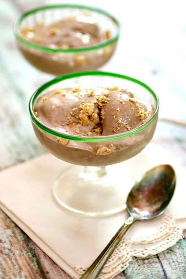Two vintage ice cream glasses with brownie ice cream in them. a silver spoon is placed nearby.
