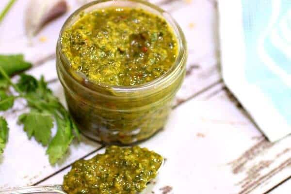 close up of chimichurri sauce in a jelly jar