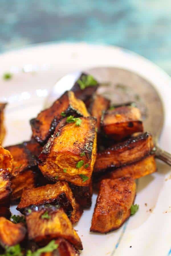 Cubed roasted sweet potatoes are spicy with chipotle and grarnished with parsley.