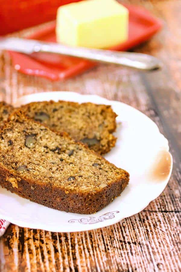 Slices of banana bread with a red butter dish in the background