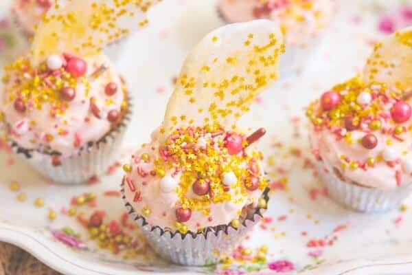 Three rose gold cupcakes on an antique plate