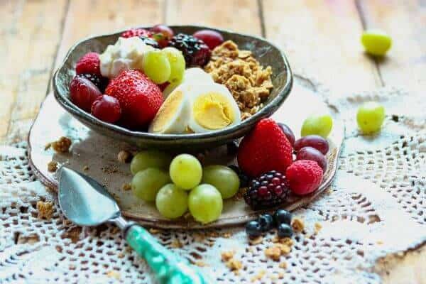 Granola, berries, eggs, and yogurt arranged in a bowl - feature image