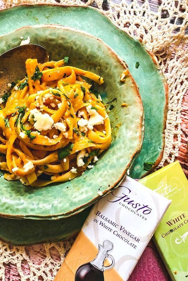 A bowl of Pumpkin Alfredo sauce on Pasta with ingredients nearby