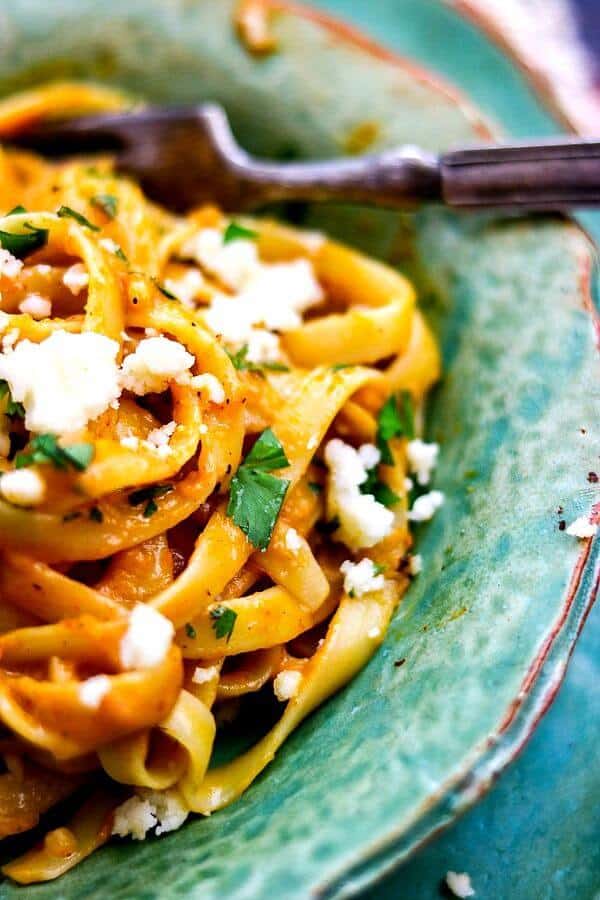 Closeup of pumpkin alfredo sauce recipe over fettuccine with cojita cheese on top