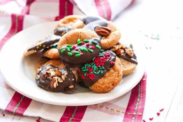 Decorated cinnamon crinkle cookies dipped in Mexican chocolate on a white plate.