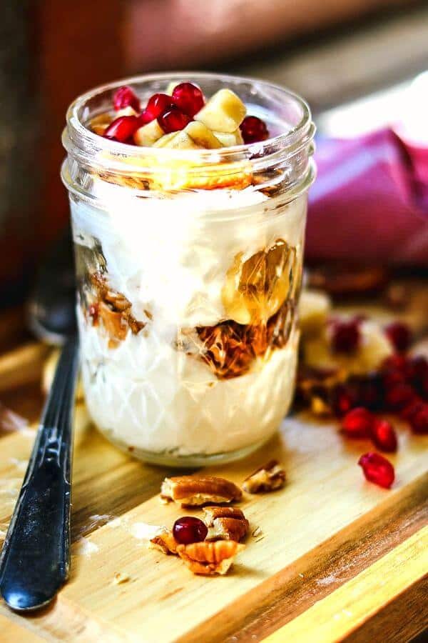 Closeup of a jar with layers of yogurt and fruit.