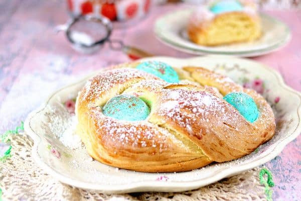 A loaf of Italian Easter bread with powdered sugar dusted over it.