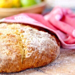 Closeup of a loaf of lavender soda bread cooling on a table.