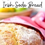 Round loaf of soda bread on a table. Text title overlay for Pinterest.