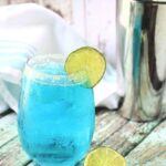 Blue cocktail in a glass with the title written on the top of the image